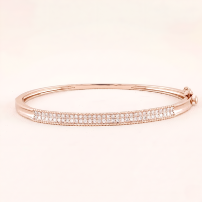 Rose gold bracelet with small diamonds on a light pink background