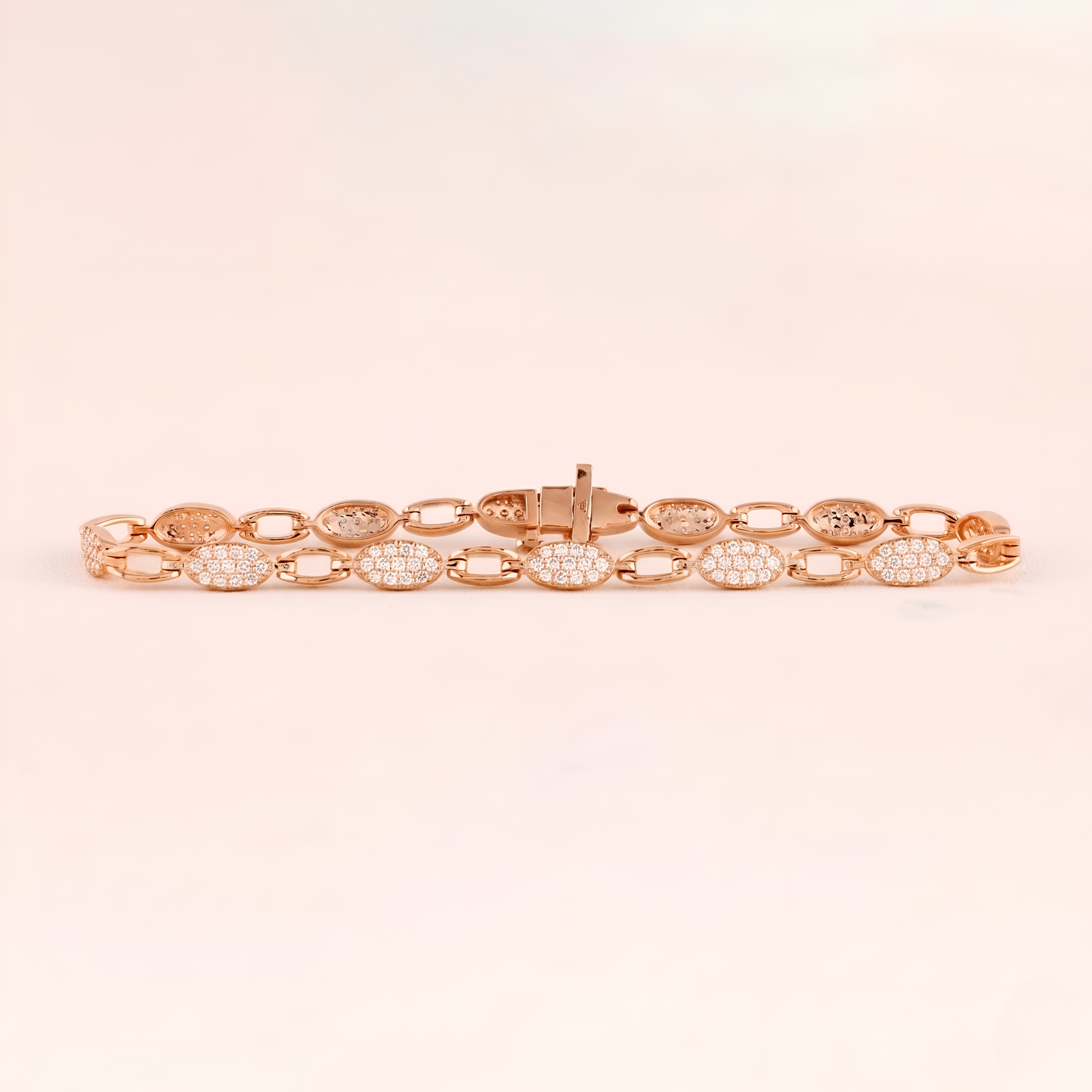 Rose gold bracelet with diamond accents on a light pink background