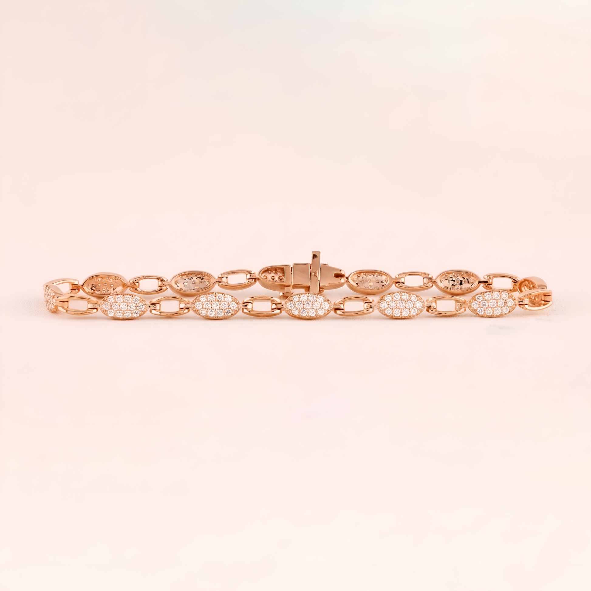 Rose gold bracelet with diamond accents on a light pink background