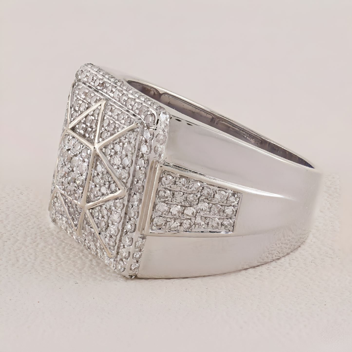 Silver ring with geometric design and embedded stones on a light background