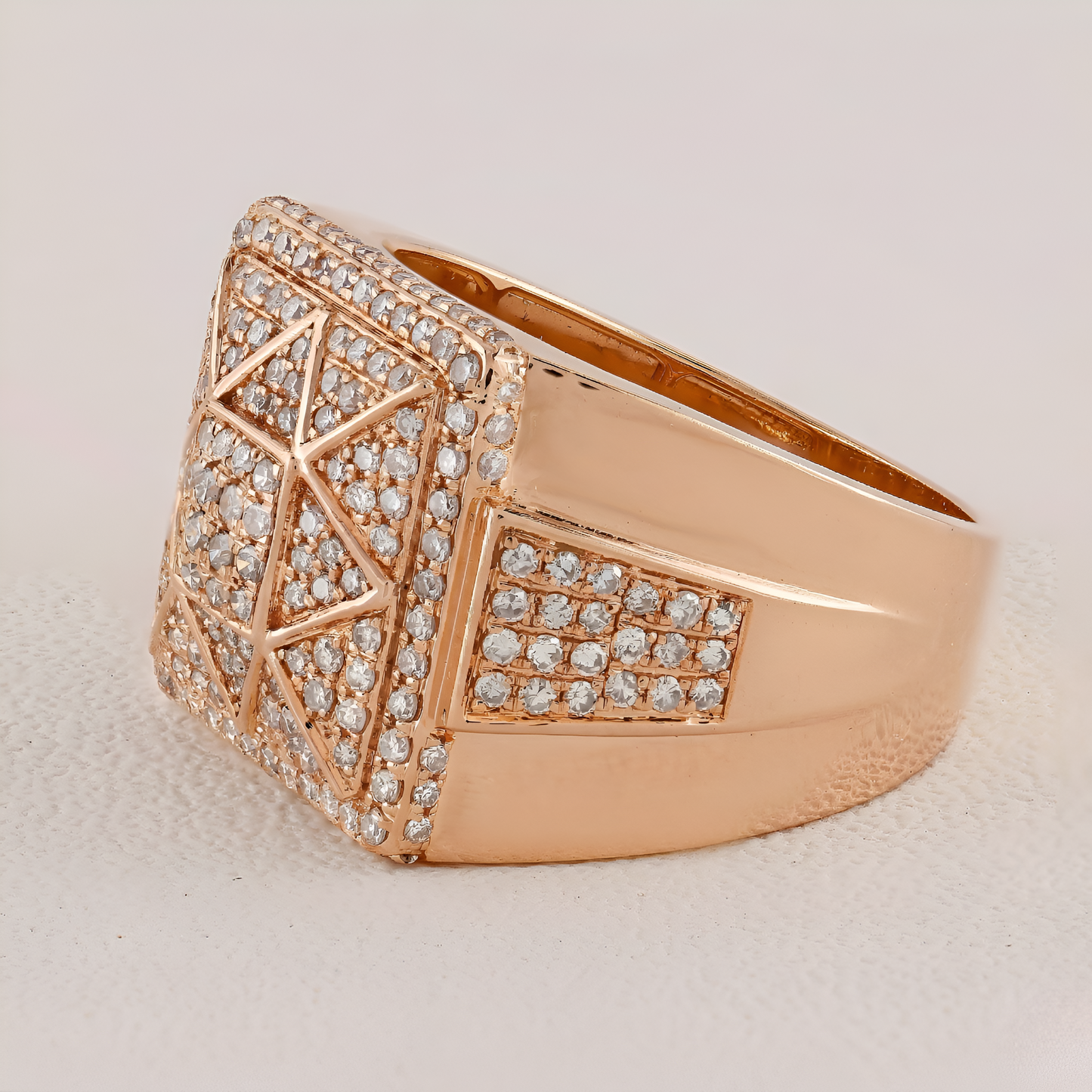 Rose gold ring with diamond accents on a light beige background