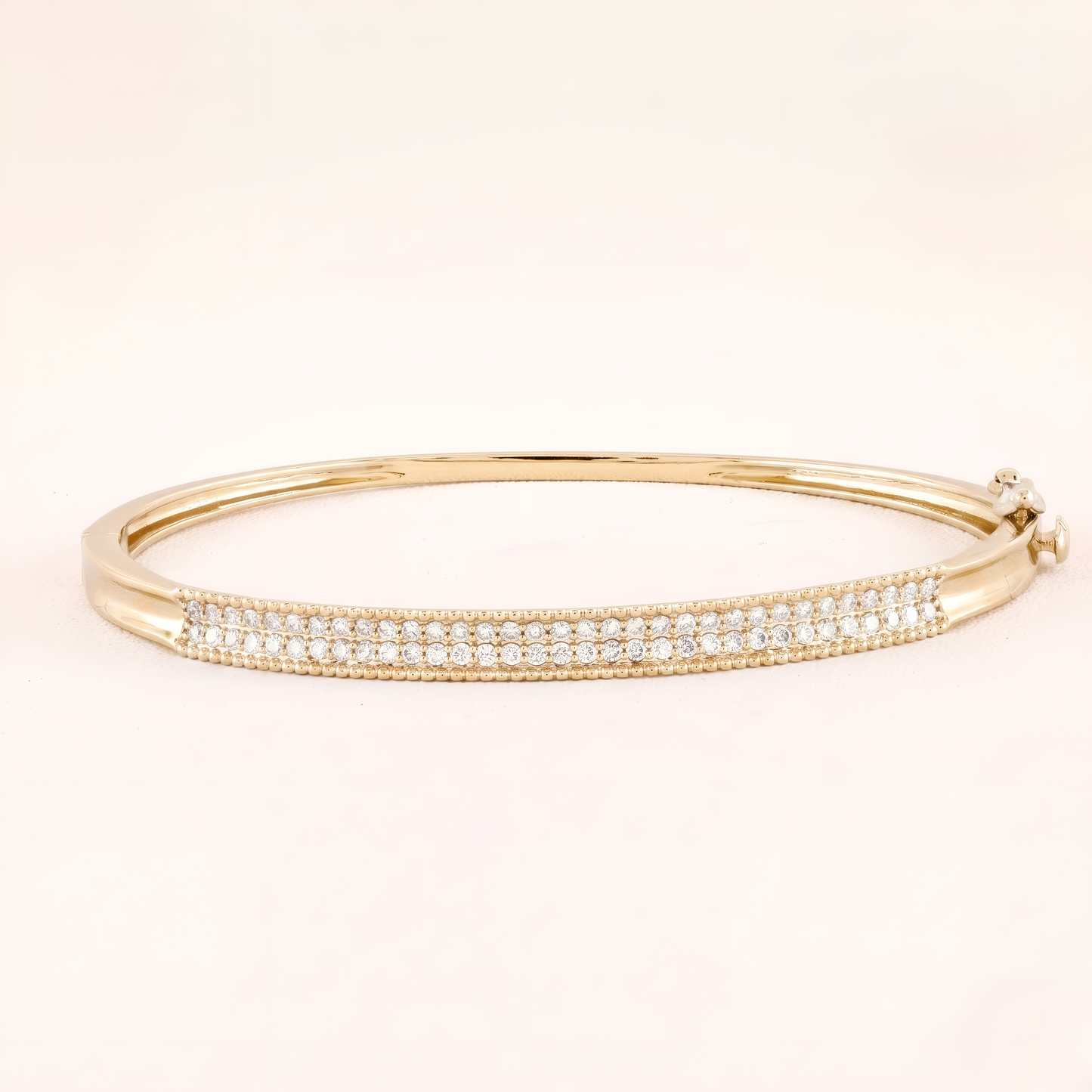 Gold bracelet with clear stones on a beige background