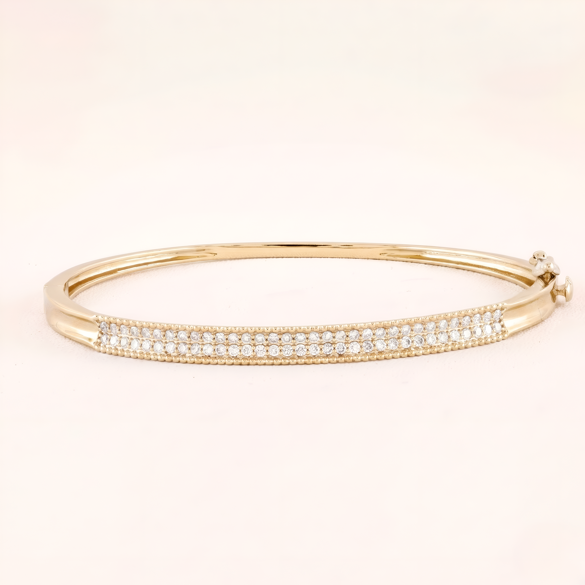 Gold bracelet with clear stones on a beige background