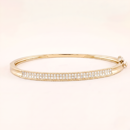 Gold bracelet with clear stones on a beige background