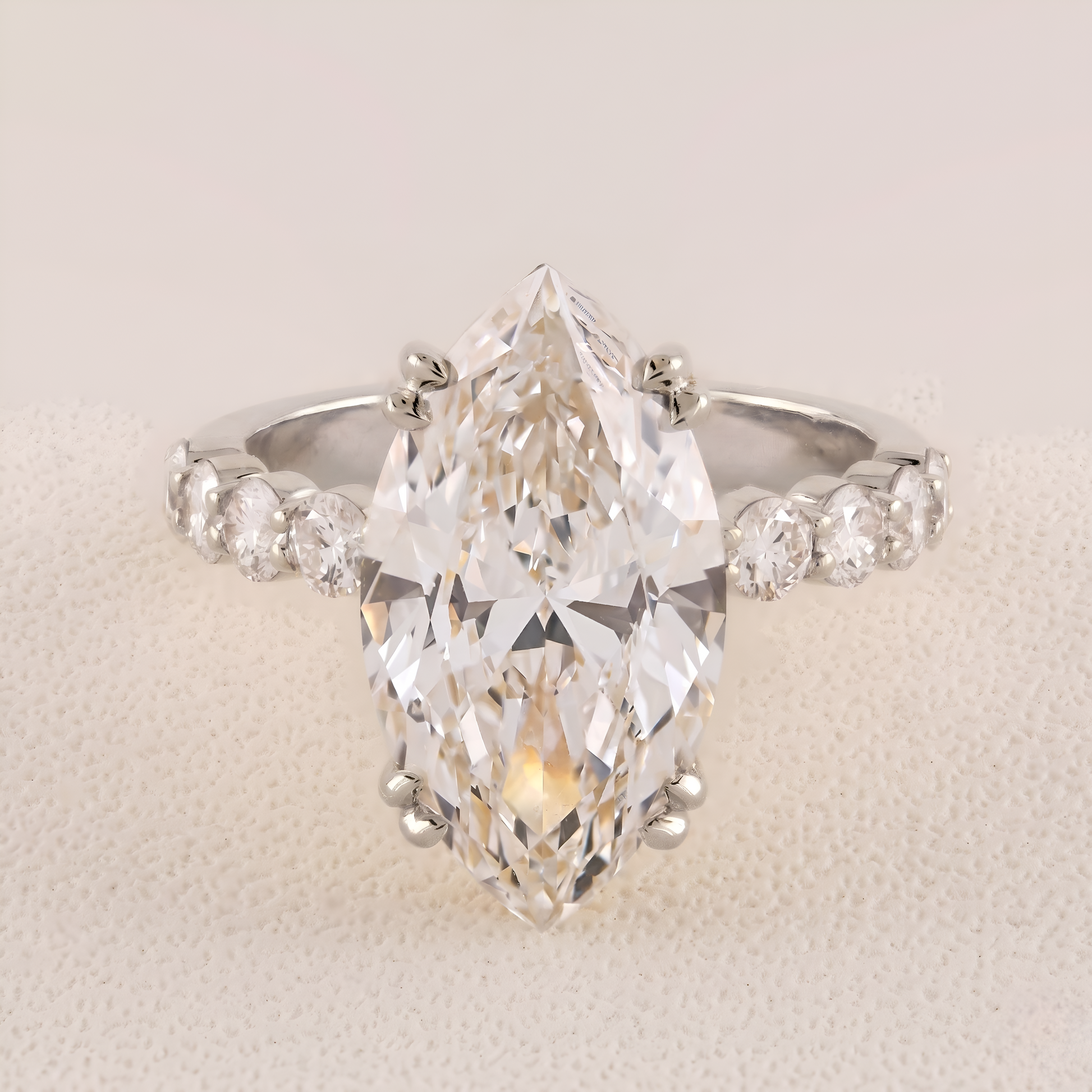 Diamond ring with a pear-shaped center stone on a light background