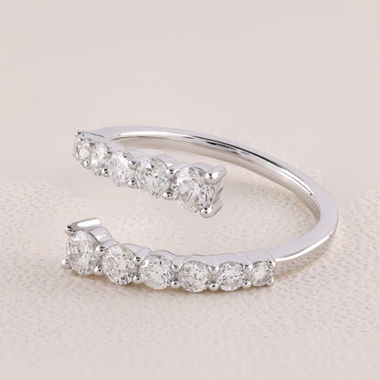 Silver open ring with embedded diamonds on a light beige background