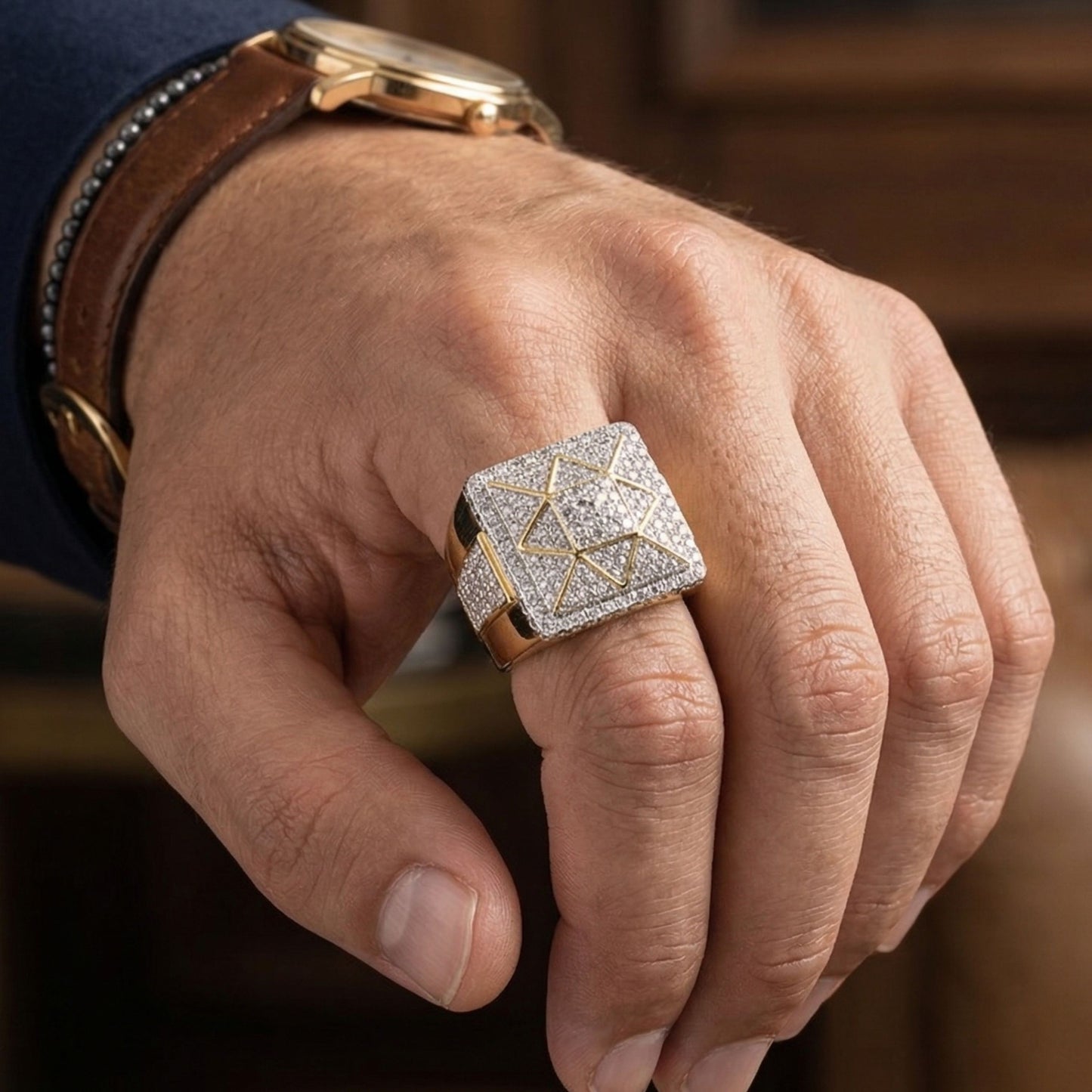 Hand wearing a gold ring with diamond accents on a blurred background