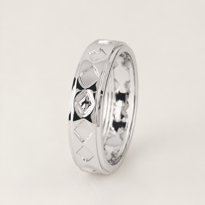 A polished silver ring with a textured geometric diamond pattern on the exterior, standing upright on a light beige background.