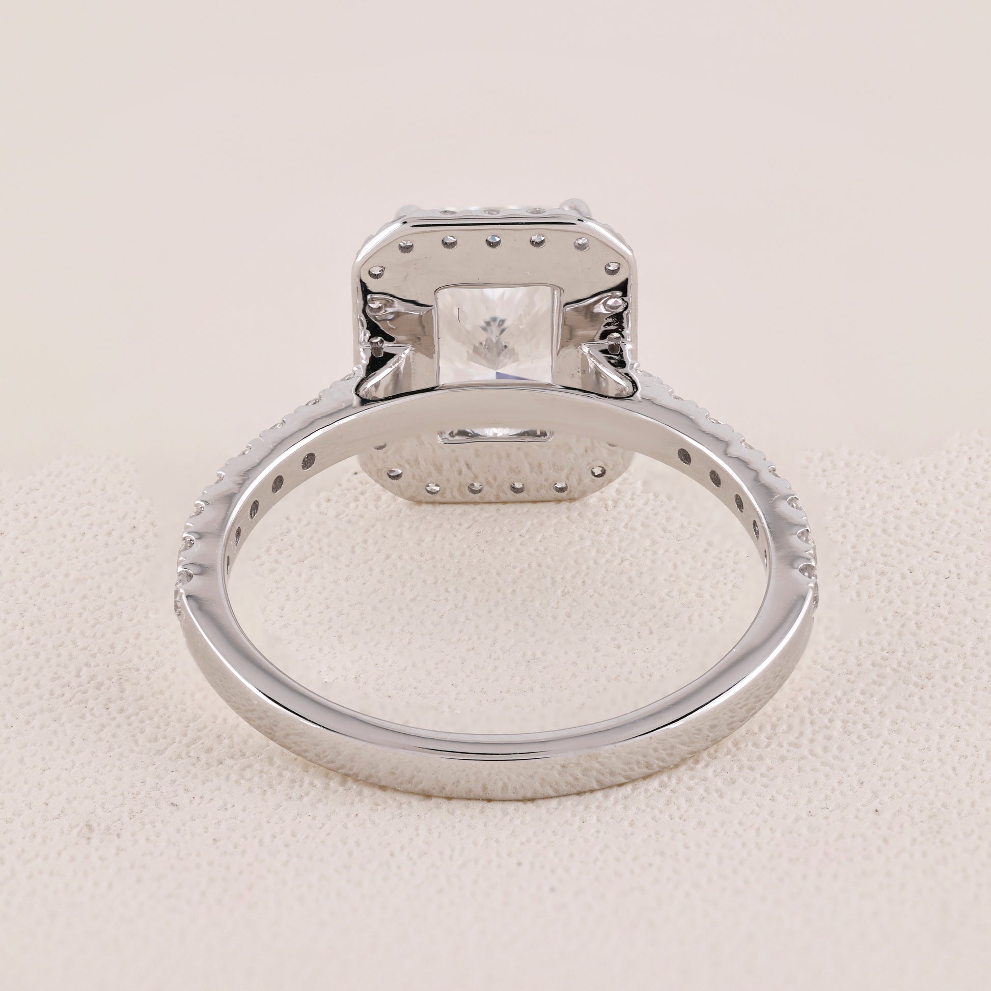Silver ring with a diamond on a light gray background