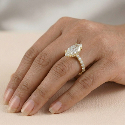 Gold ring with a large diamond on a hand against a neutral background