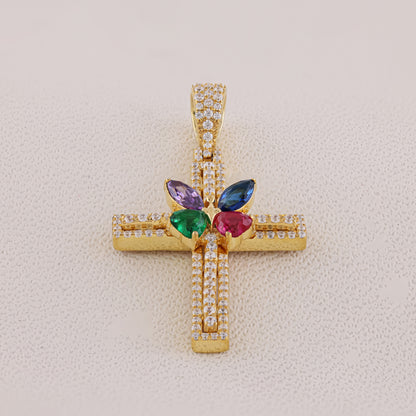 Gold cross pendant with colorful gemstones on a light beige background