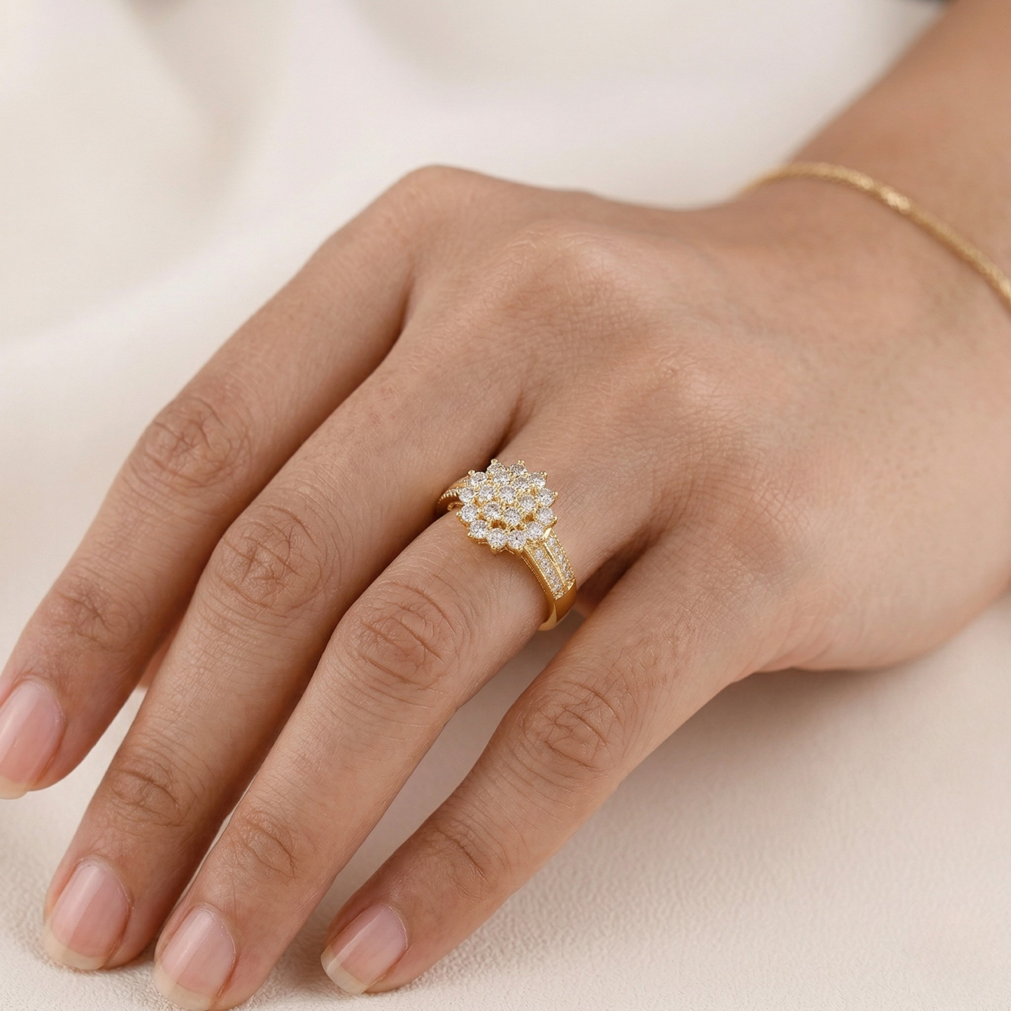 Gold ring with diamonds on a hand against a neutral background