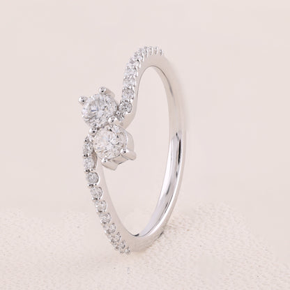 Silver ring with diamond accents on a light pink background