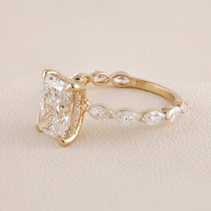 Gold ring with a large diamond and smaller stones on a beige background