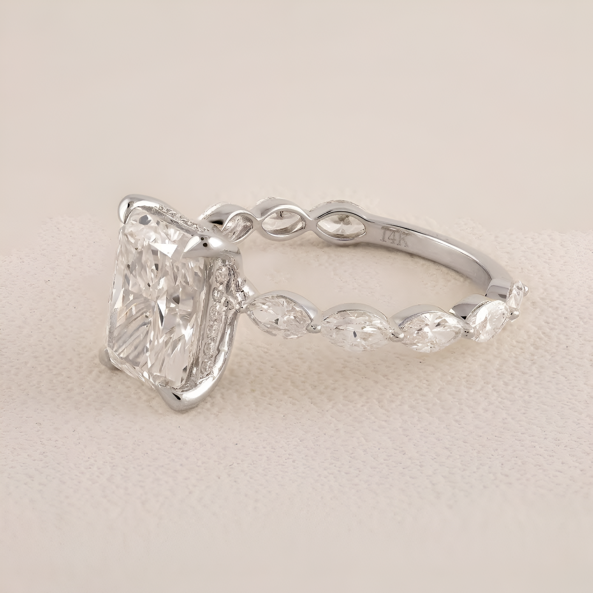 Silver ring with a large diamond on a light beige background