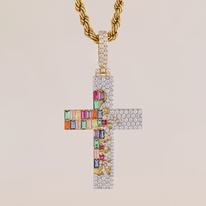Gold cross pendant with colorful gemstones on a beige background