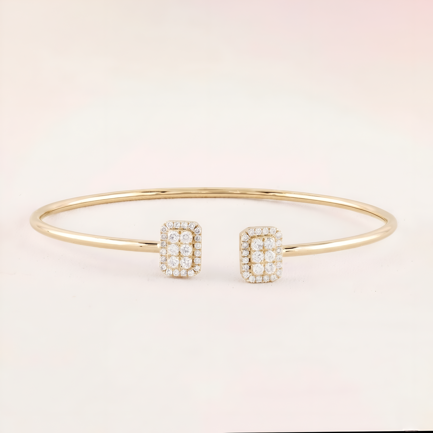 Gold bracelet and earrings on a light pink background