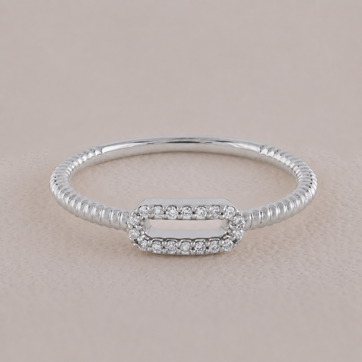 Silver bracelet with a rectangular clasp on a beige background