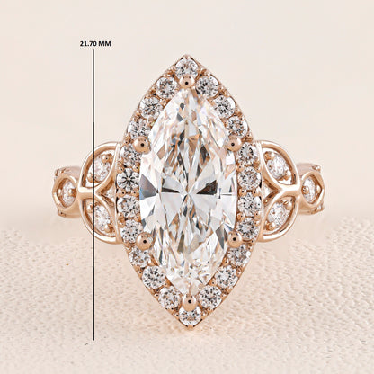 Rose gold ring with a large diamond and smaller diamonds around on a beige background