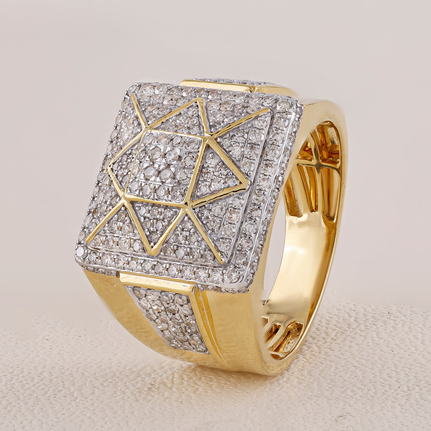 Gold ring with diamond-studded geometric design on a light gray background