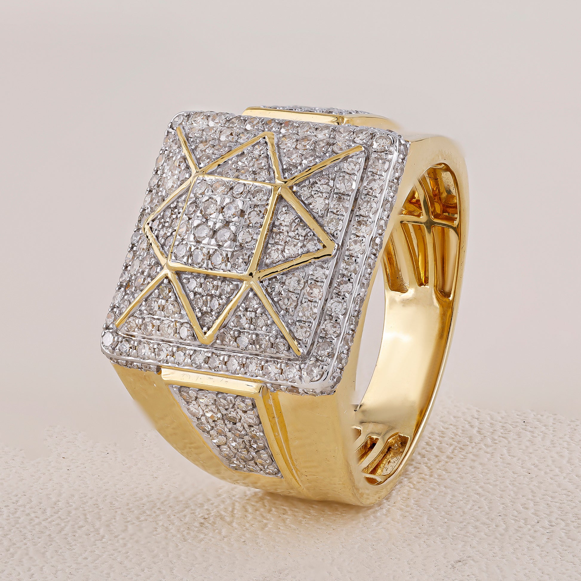 Gold ring with diamond-studded geometric design on a light gray background