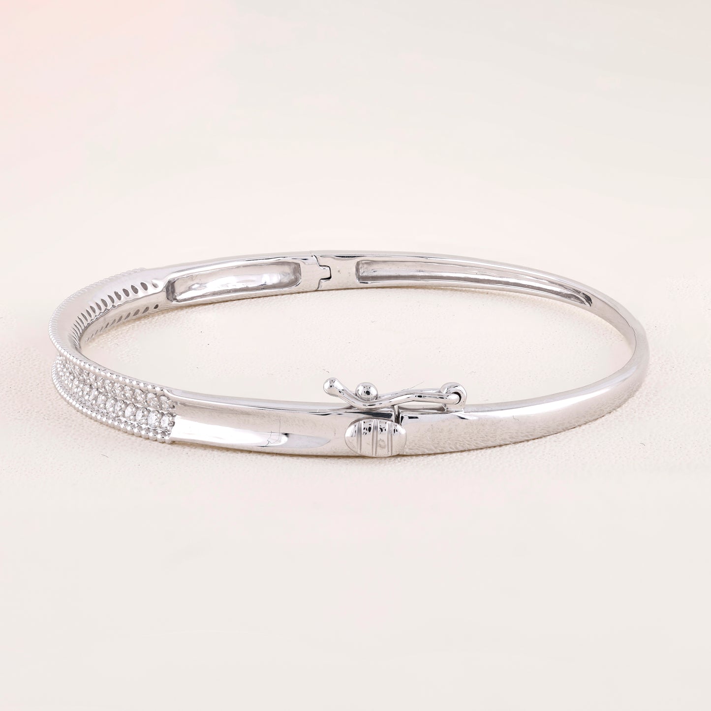 Silver bracelet on a light beige background