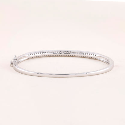 Silver bangle on a light pink background