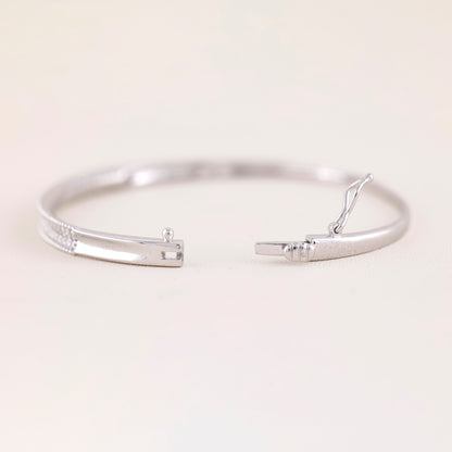 Two silver bangles on a light beige background