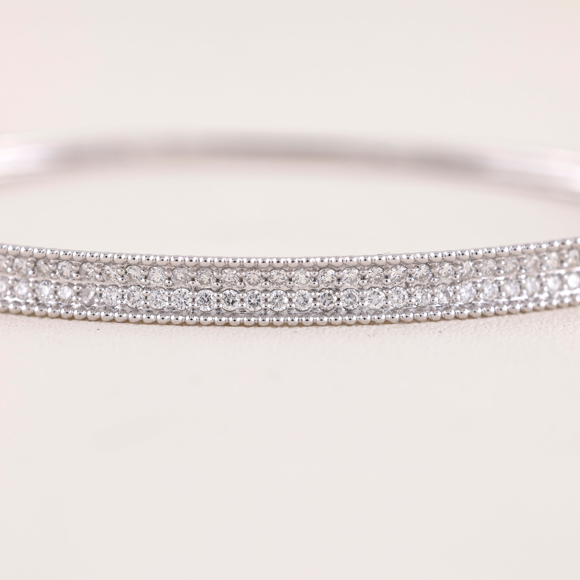 Close-up of a silver bracelet with clear stones on a white background