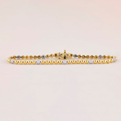Gold bracelet with embedded diamonds on a light beige background