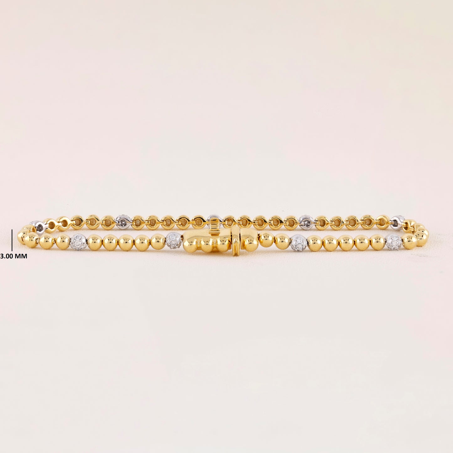 Gold bracelet with small beads on a light beige background