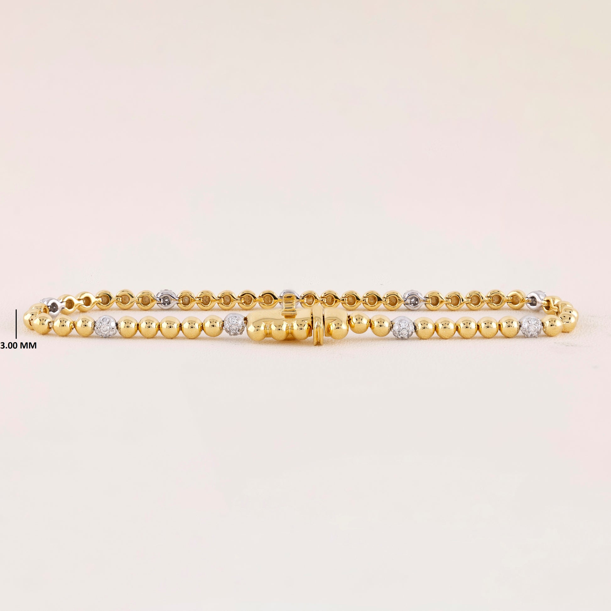 Gold bracelet with small beads on a light beige background