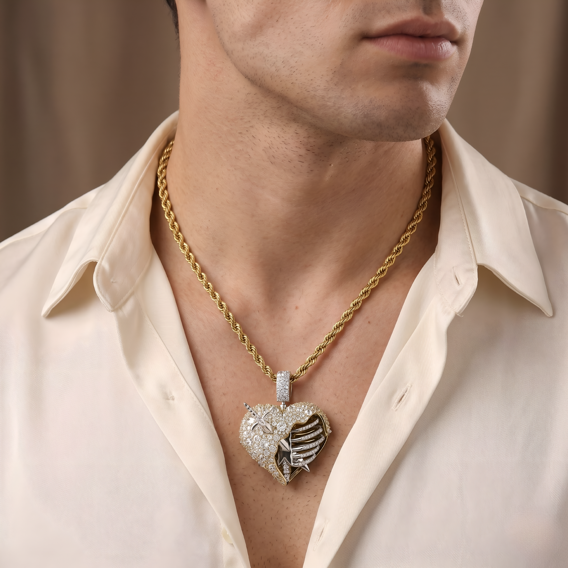 Man wearing a gold chain with a heart-shaped diamond pendant on a neutral background