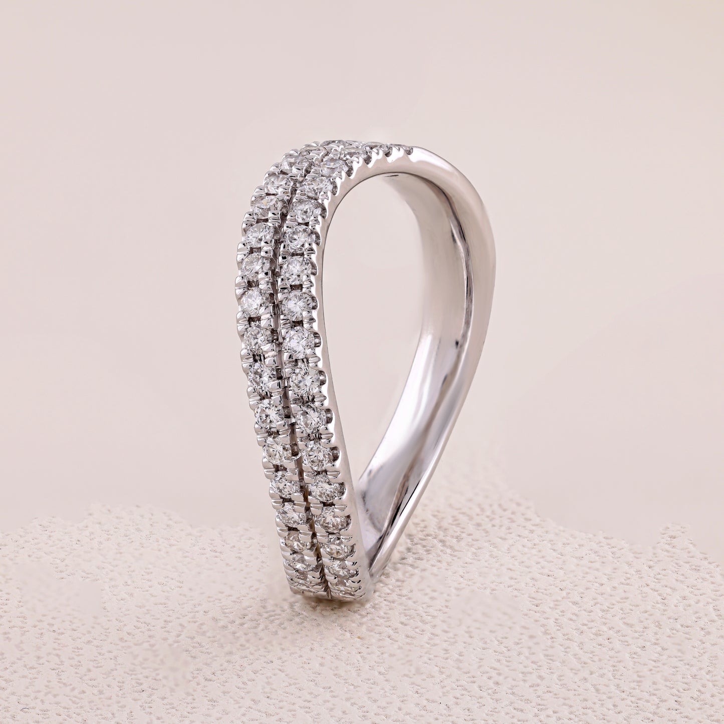 Silver ring with diamond accents on a beige fabric background