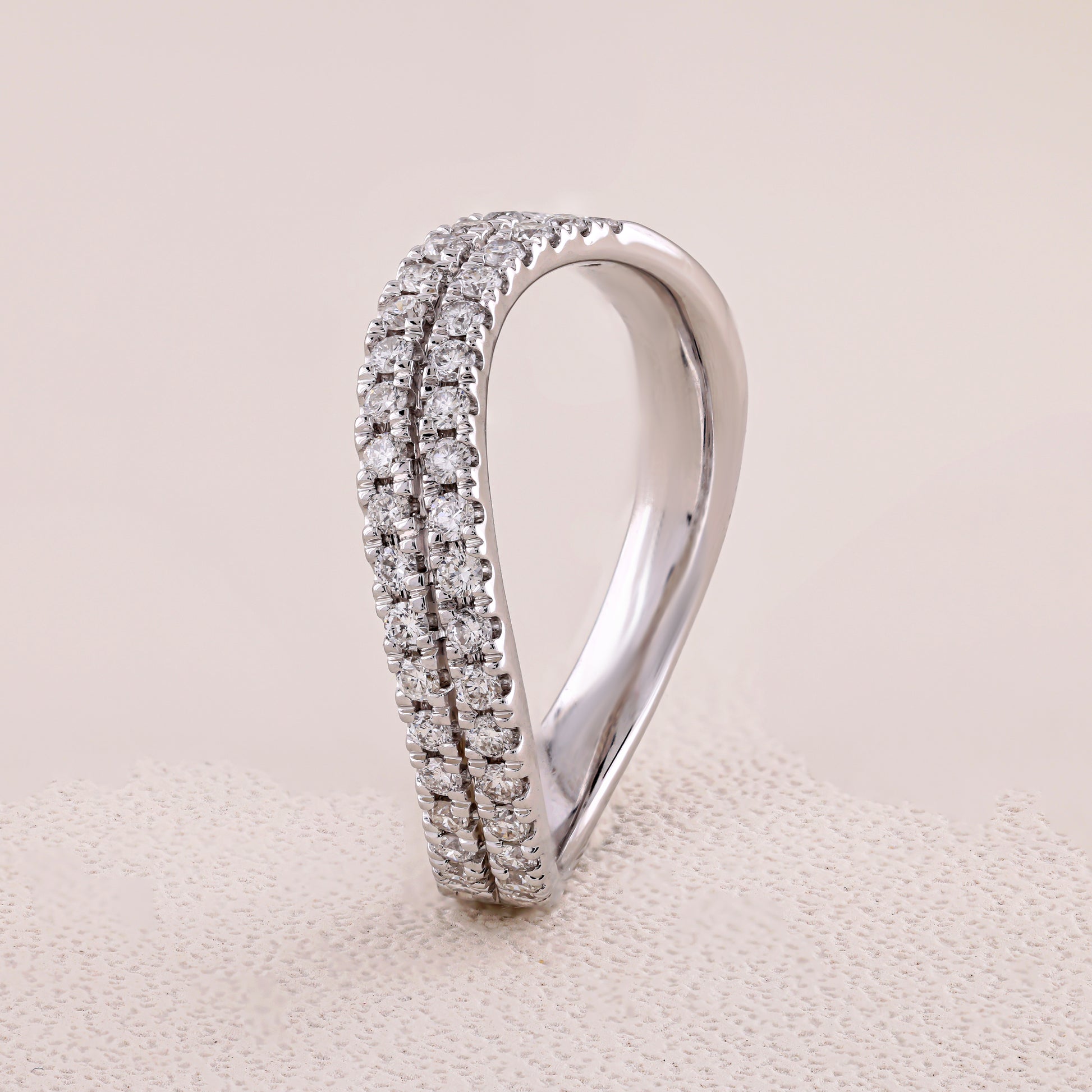 Silver ring with diamond accents on a beige fabric background