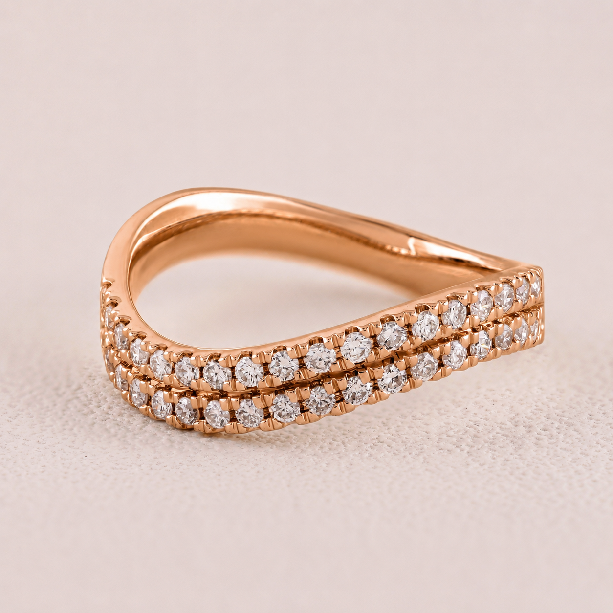 Rose gold ring with diamond accents on a beige background