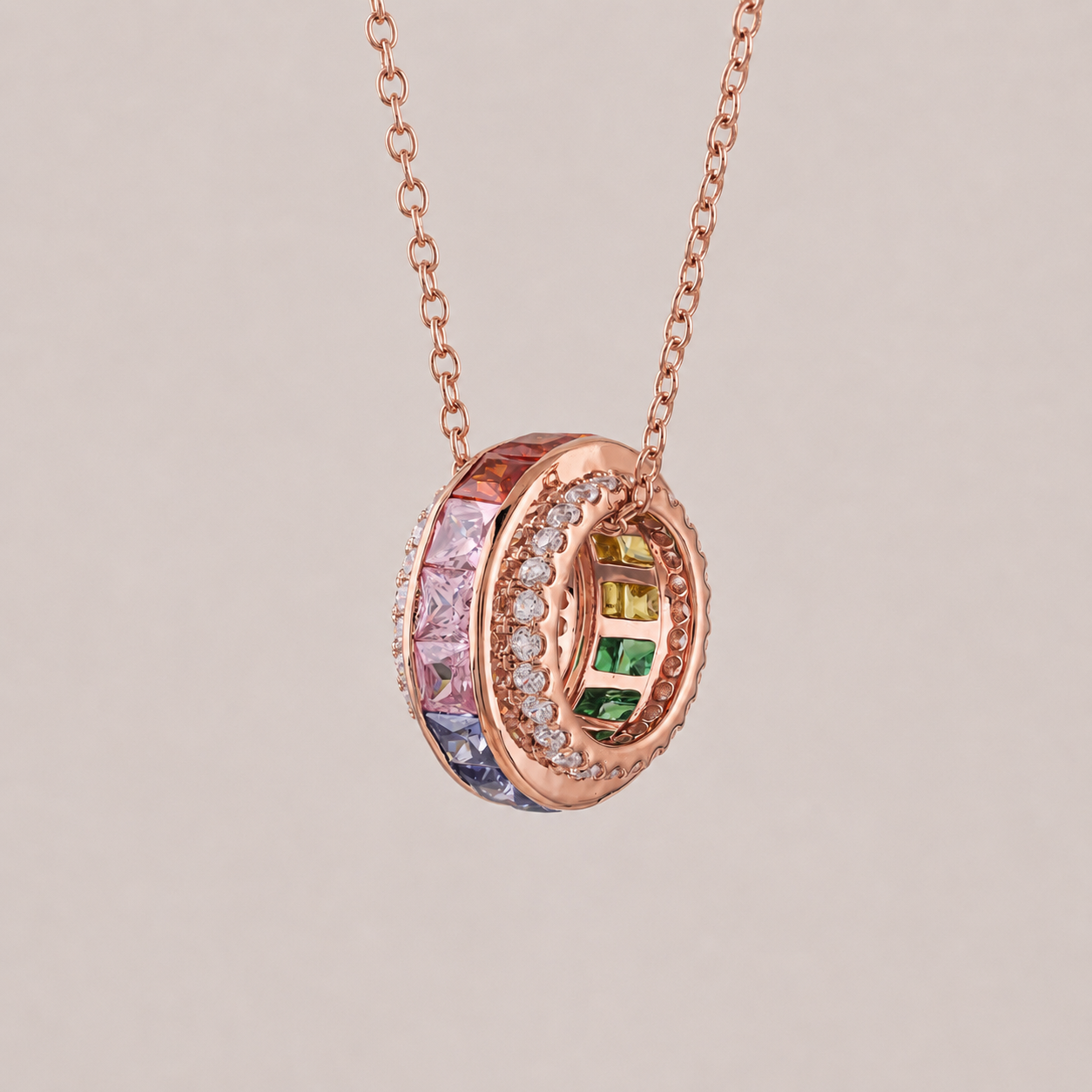 Rose gold necklace with a multicolored gemstone pendant on a light gray background