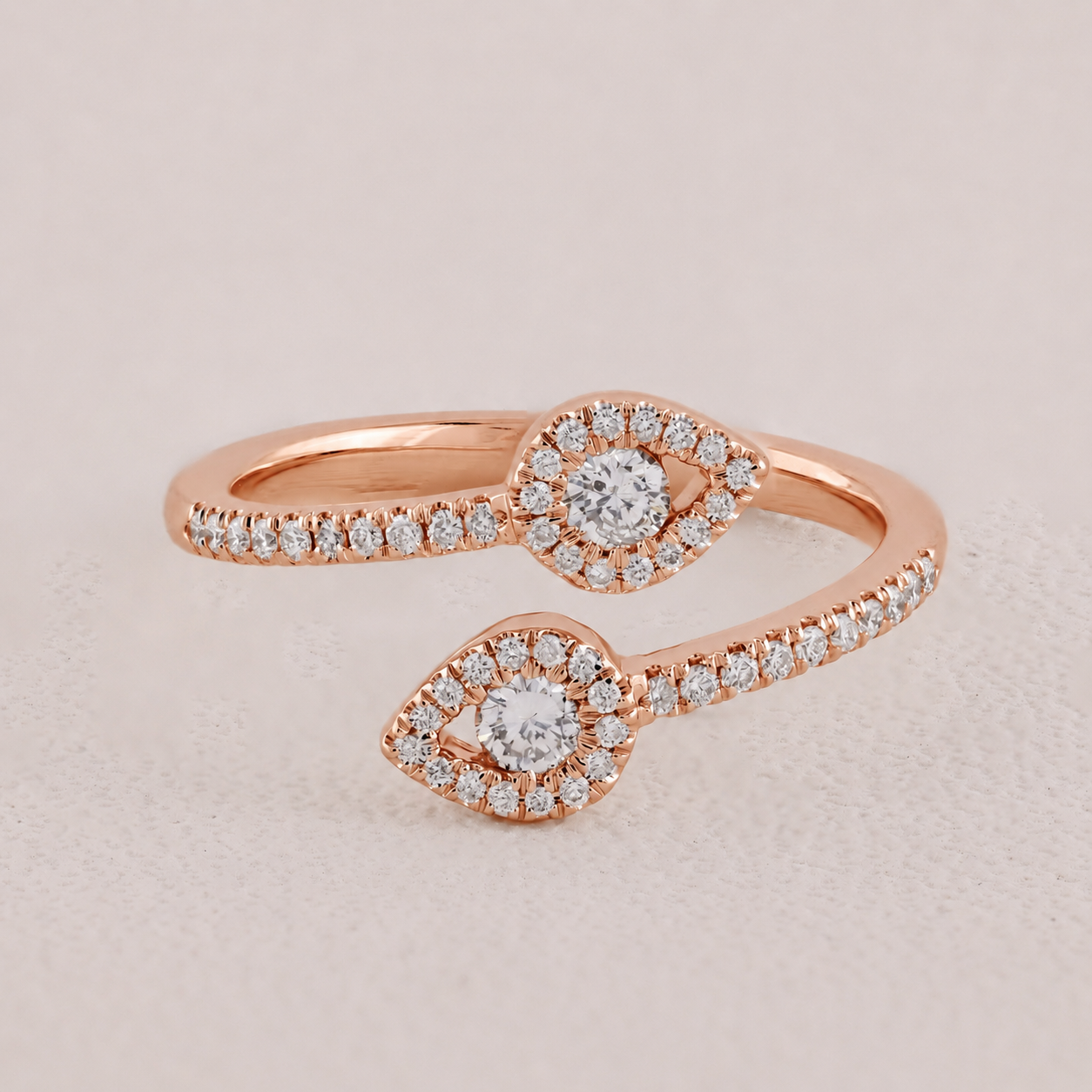 Rose gold ring with diamond accents on a light beige background