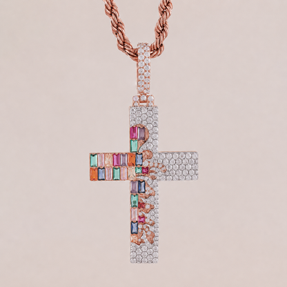Cross-shaped pendant with colorful gemstones and rose gold chain on beige background