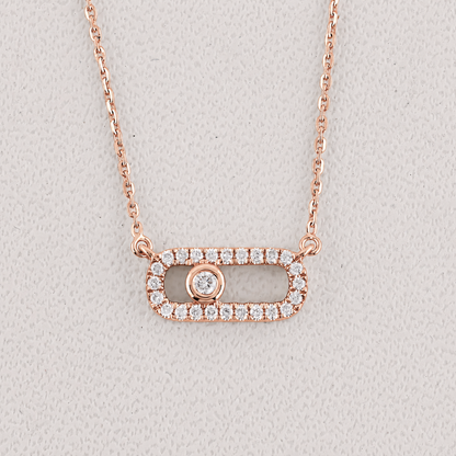 Rose gold necklace with a rectangular pendant on a light gray background