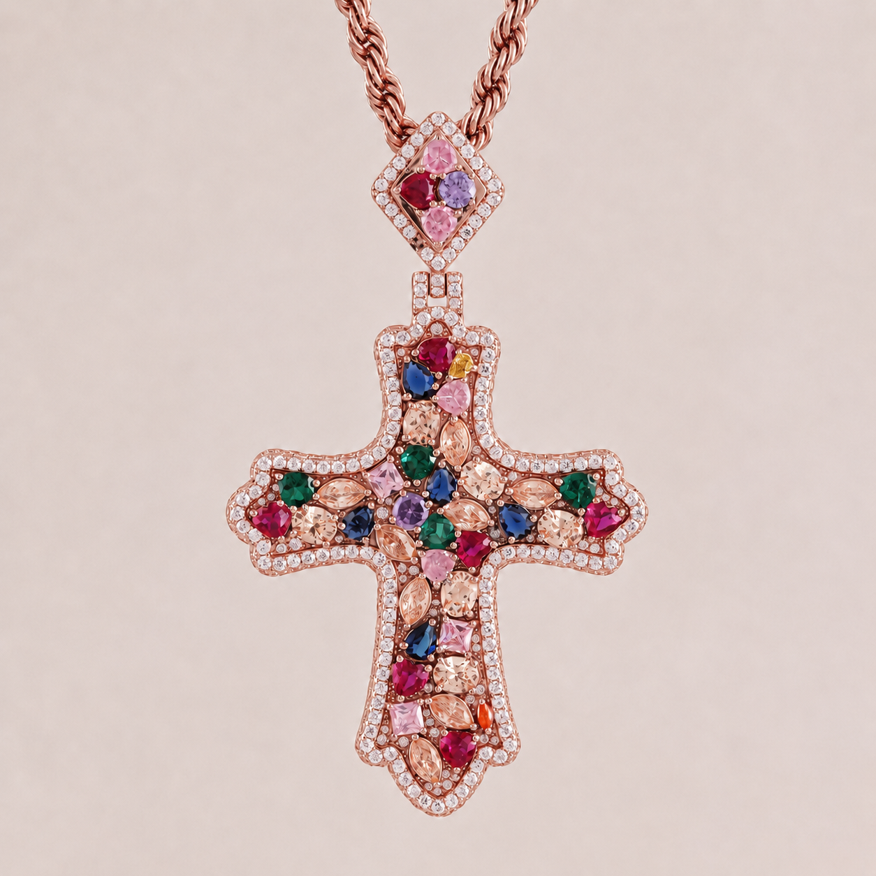 Cross-shaped pendant with colorful gemstones and rose gold chain on beige background