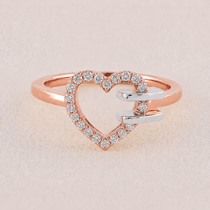 Heart-shaped ring with rose gold and silver tones on a light beige background