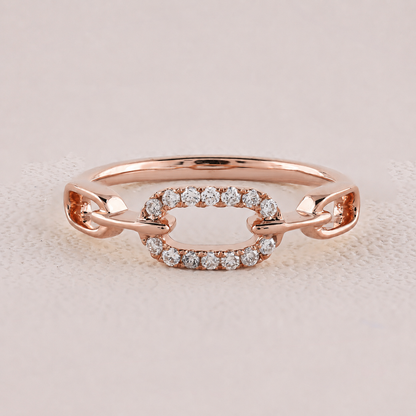 Rose gold ring with diamond accents on a light pink background