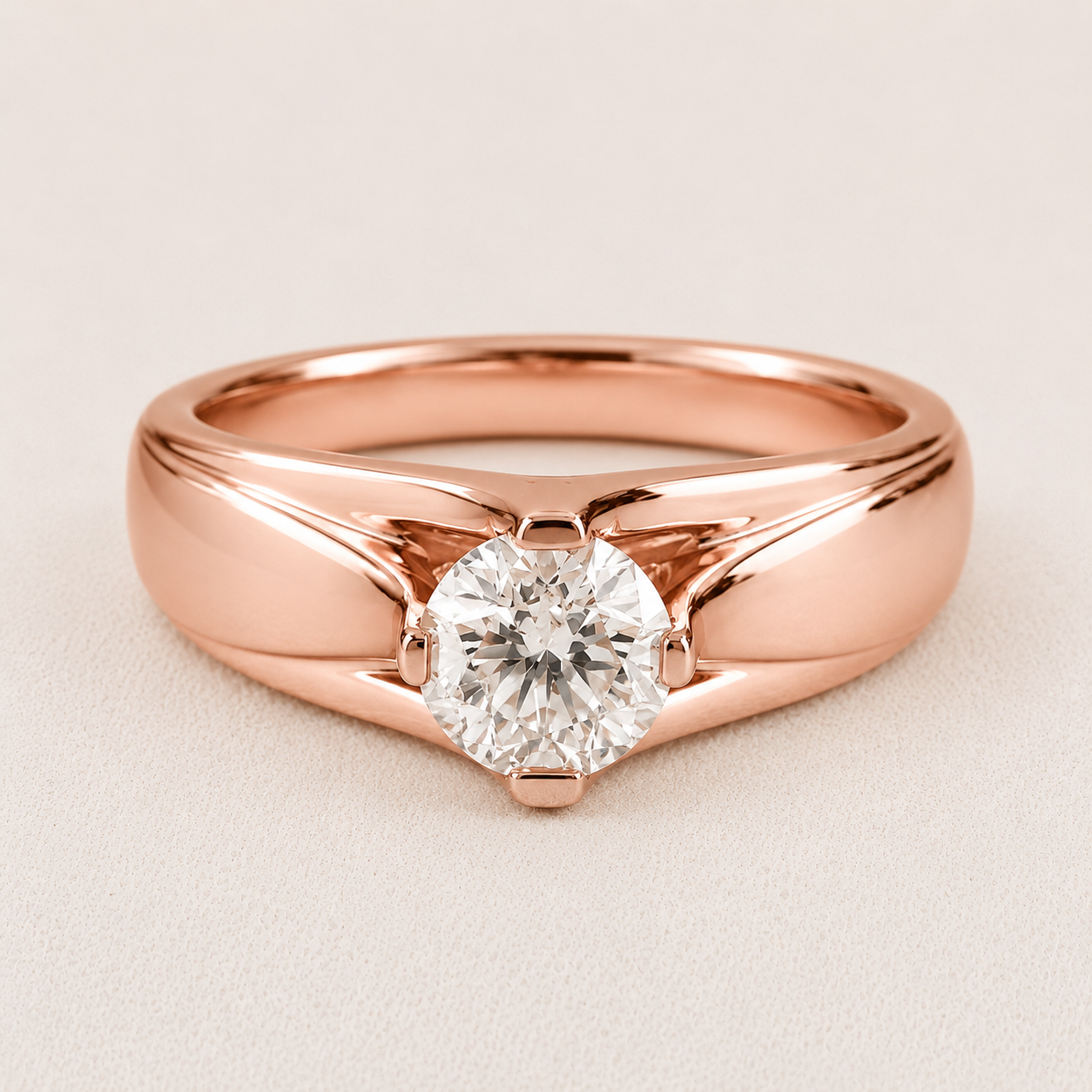 A rose gold solitaire engagement ring with a round brilliant-cut diamond, set on a light beige textured background.