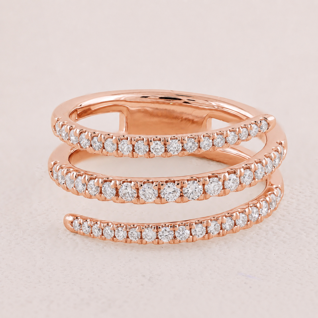 Rose gold ring with diamond accents on a light pink background