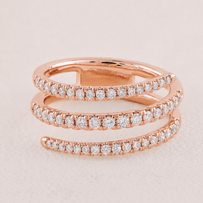 Rose gold ring with diamond accents on a light pink background