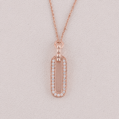 Rose gold necklace with a rectangular pendant on a light gray background