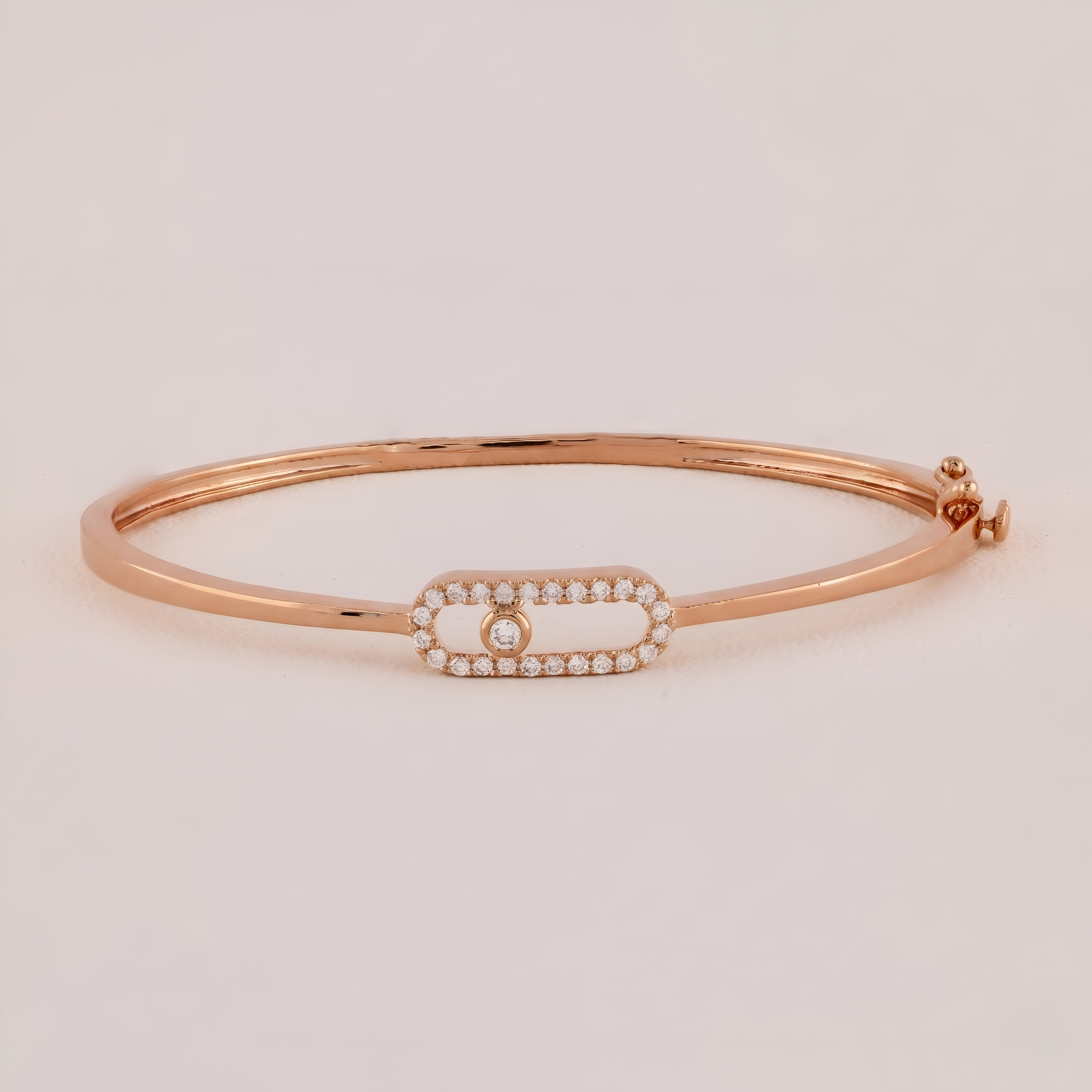 Rose gold bracelet with a diamond on a light beige background