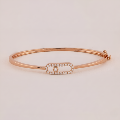Rose gold bracelet with a diamond on a light beige background