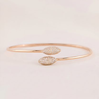 Rose gold bracelet with diamond accents on a light beige background